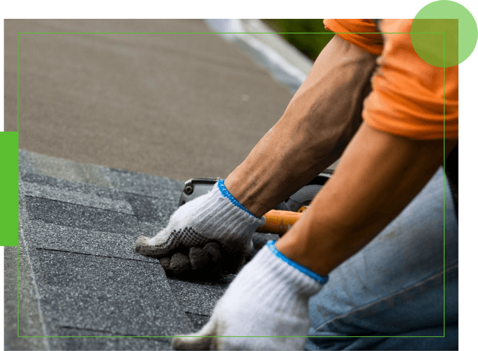 A person with gloves on working on the roof of their home.